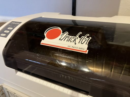 Das Druck 161-Logo klebt als Konturschnitt auf einem Plotter.